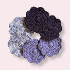 Purple crocheted coasters arranged on plain background