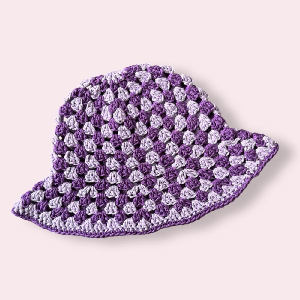 Purple striped crochet bucket hat on a plain background