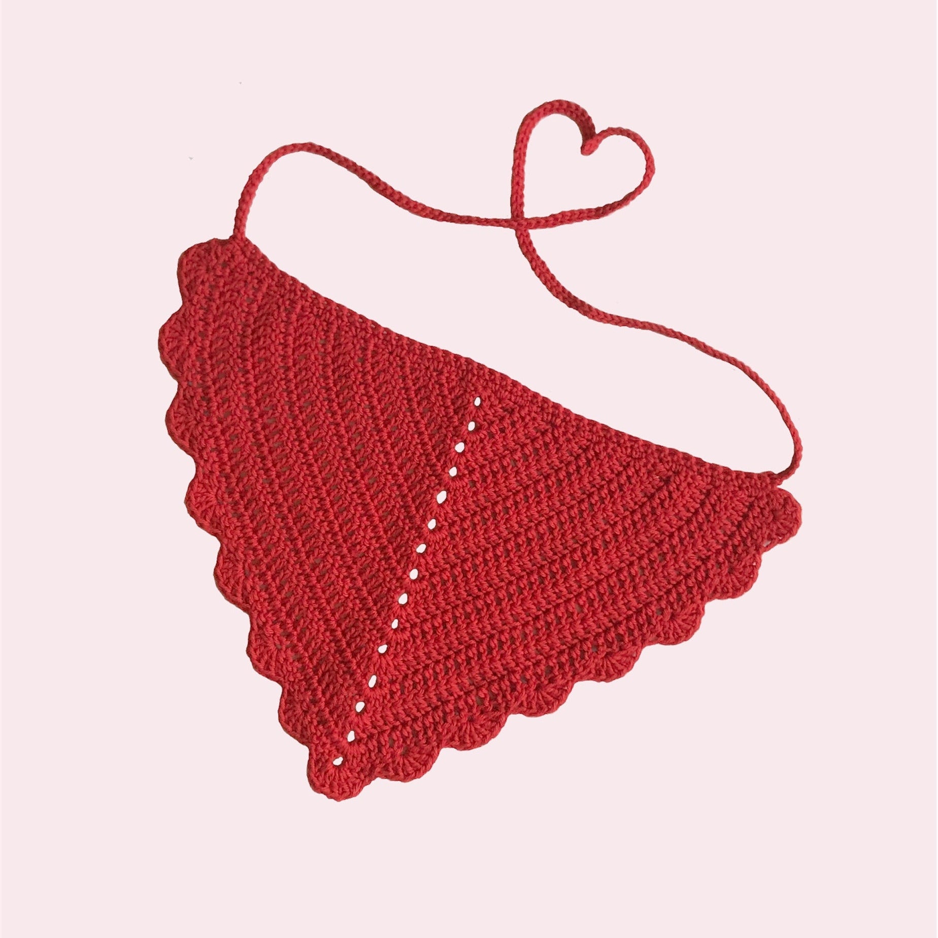 Red crochet bandana with scalloped edges on a light pink background