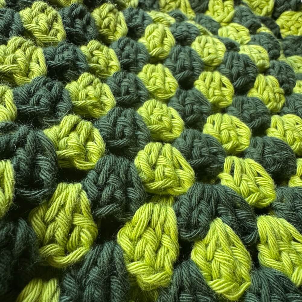 Up close texture shot of green striped crochet bucket hat 