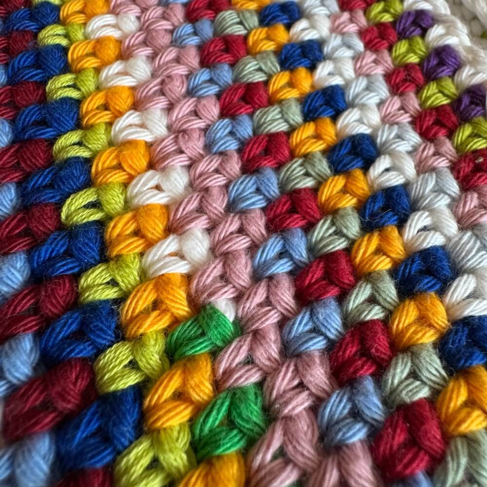 Up close texture shot of multicolor crochet purse