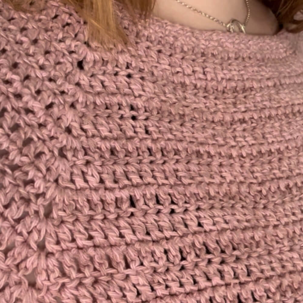 Up close texture shot of person wearing pink crochet tee
