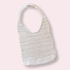 White crochet mesh tote bag on plain background