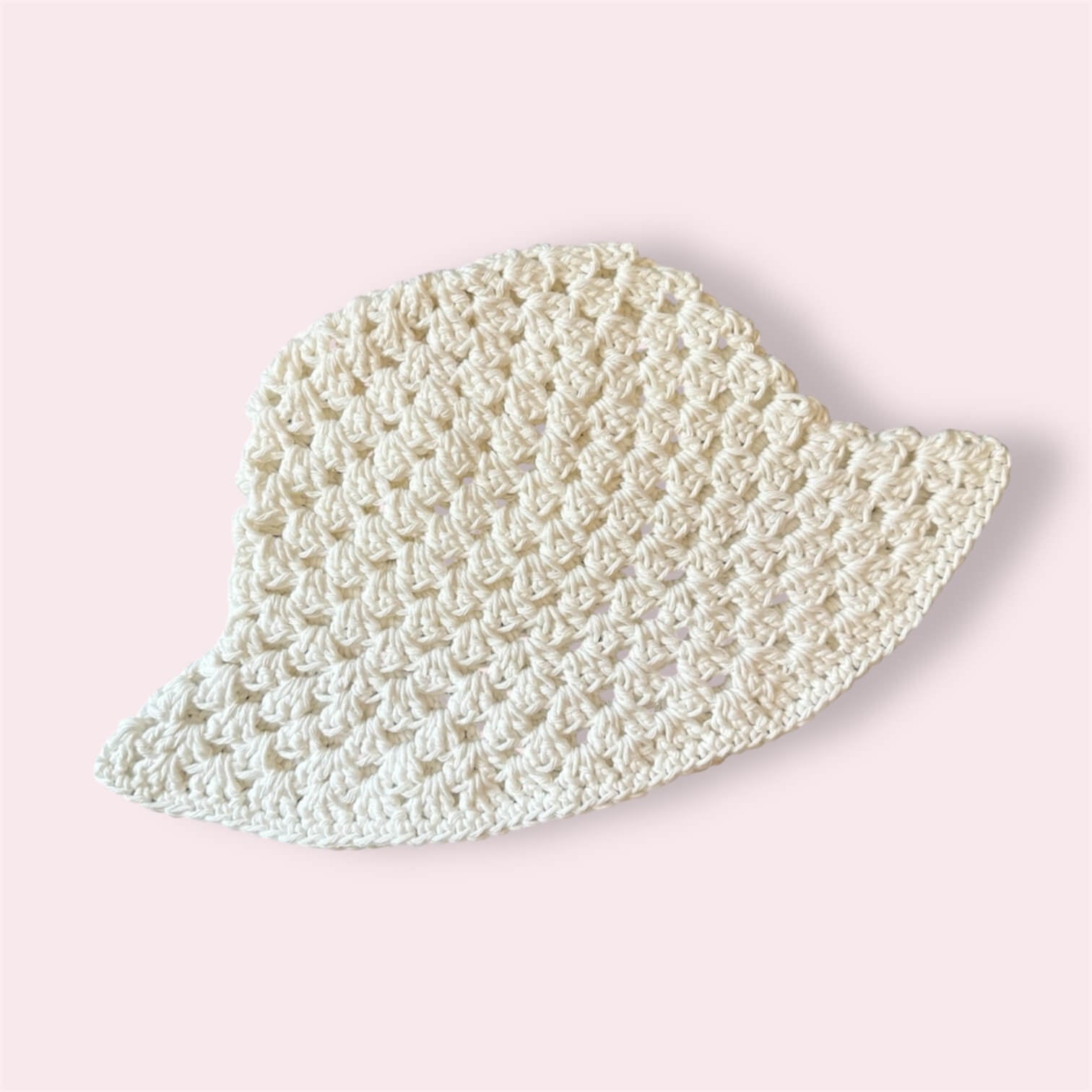 White crocheted bucket hat on plain background