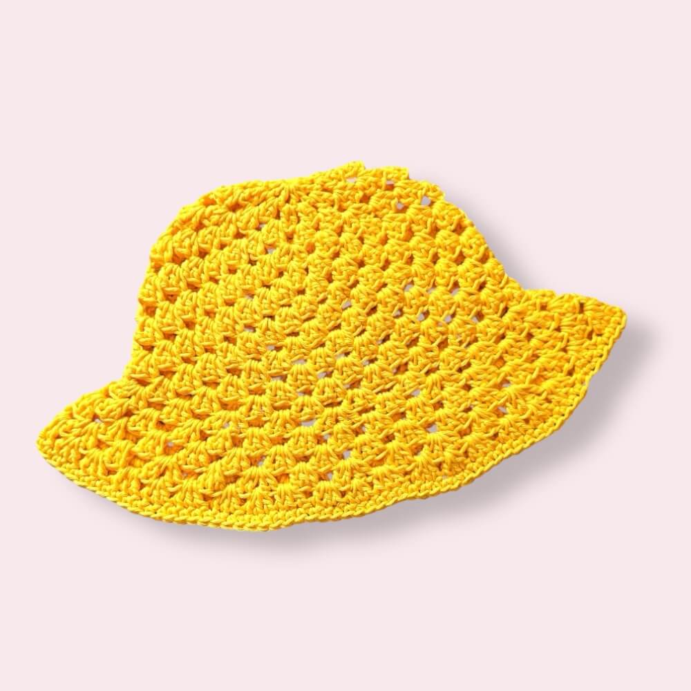 Yellow crochet bucket hat on plain background
